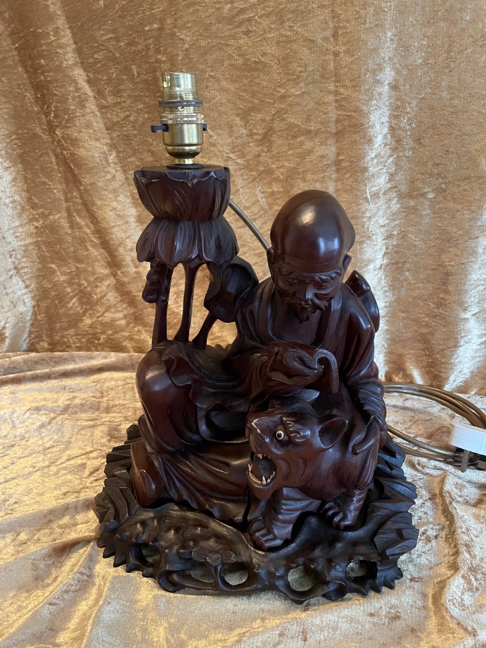 Late nineteenth-century Chinese carved dark wood table lamp depicting a seated scholar figure reading beside a tiger on a carved base with brass bulb holder. View VII