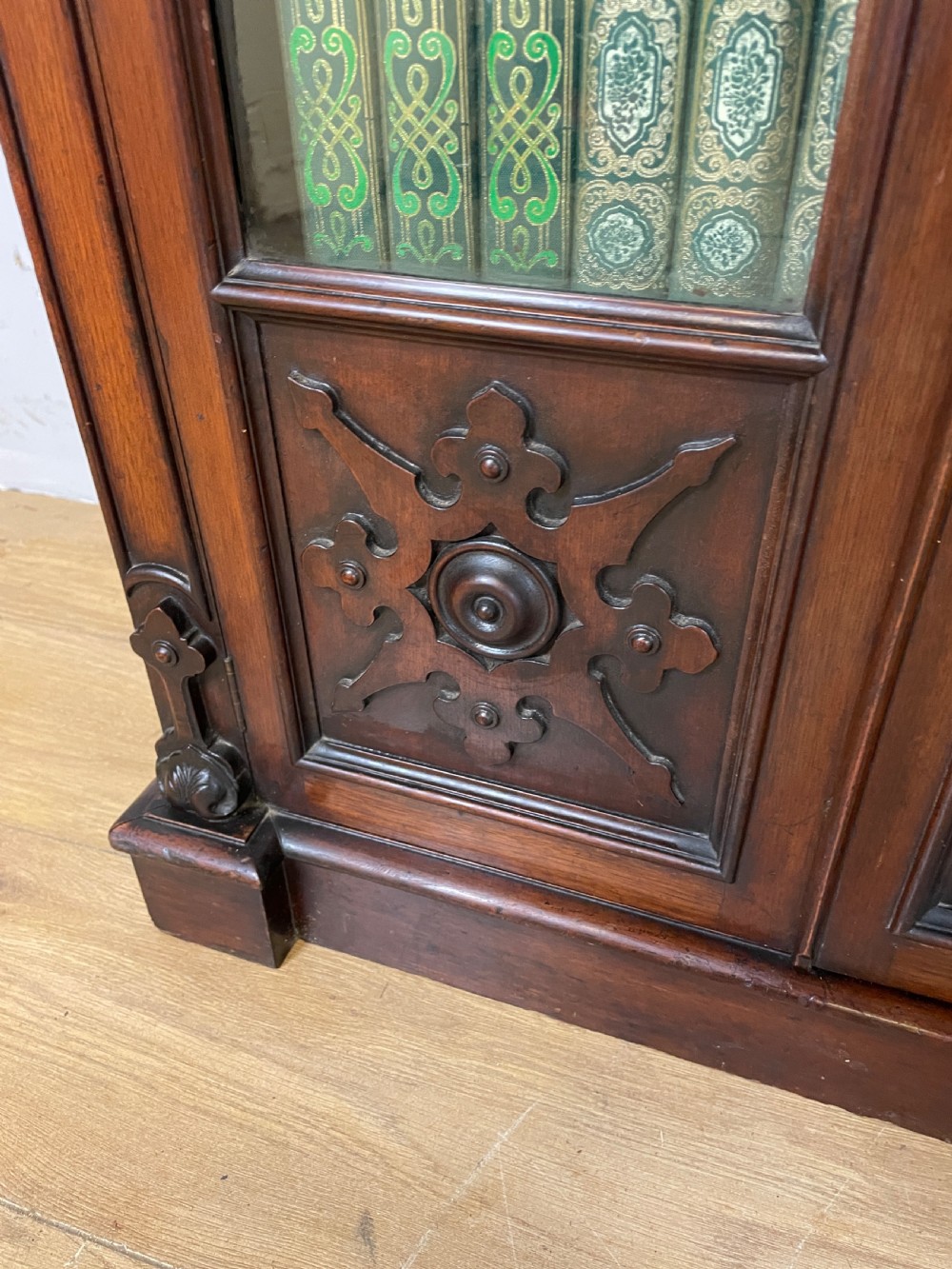A nineteenth-century walnut low bookcase featuring four arched glazed doors with carved Gothic Revival panel detailing. View V