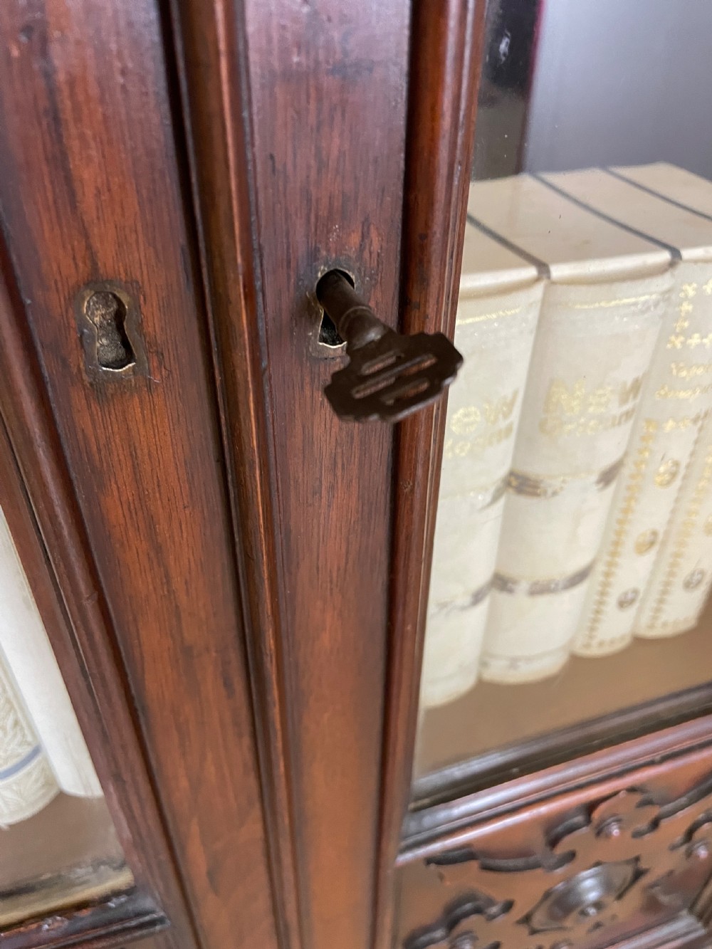 A nineteenth-century walnut low bookcase featuring four arched glazed doors with carved Gothic Revival panel detailing. View VIII