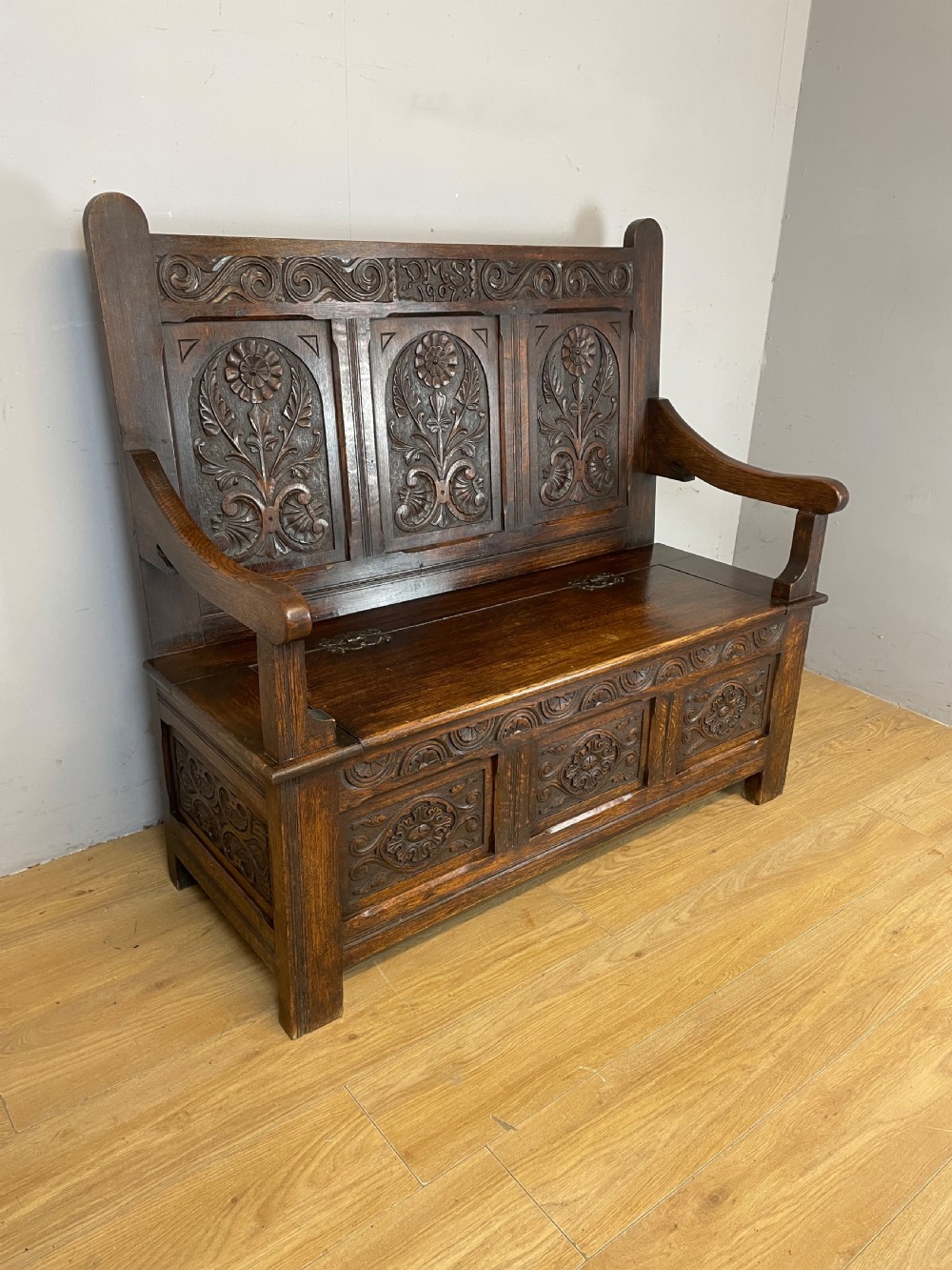 Arts and crafts solid oak carved box settle dated 1907