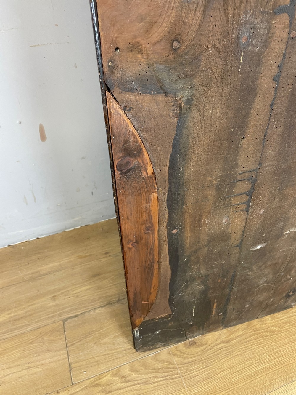 An early eighteenth-century dark oak corner cupboard featuring an arched top, leaded diamond glass door, and raised lower panels. View X