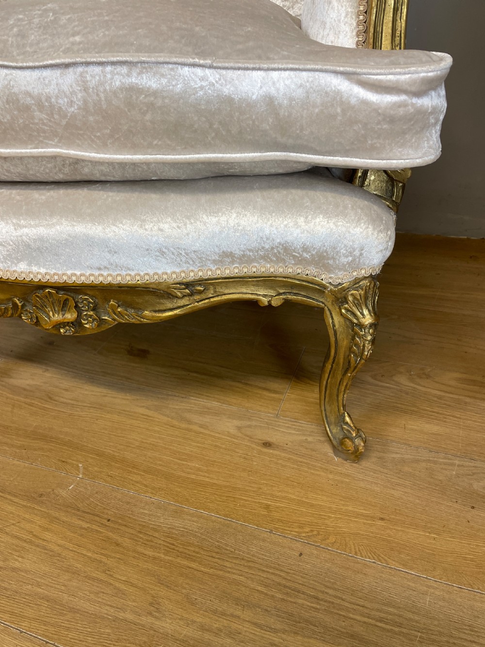 A pair of early twentieth-century French winged armchairs with carved gilded wooden frames and cream velvet upholstery. View XI