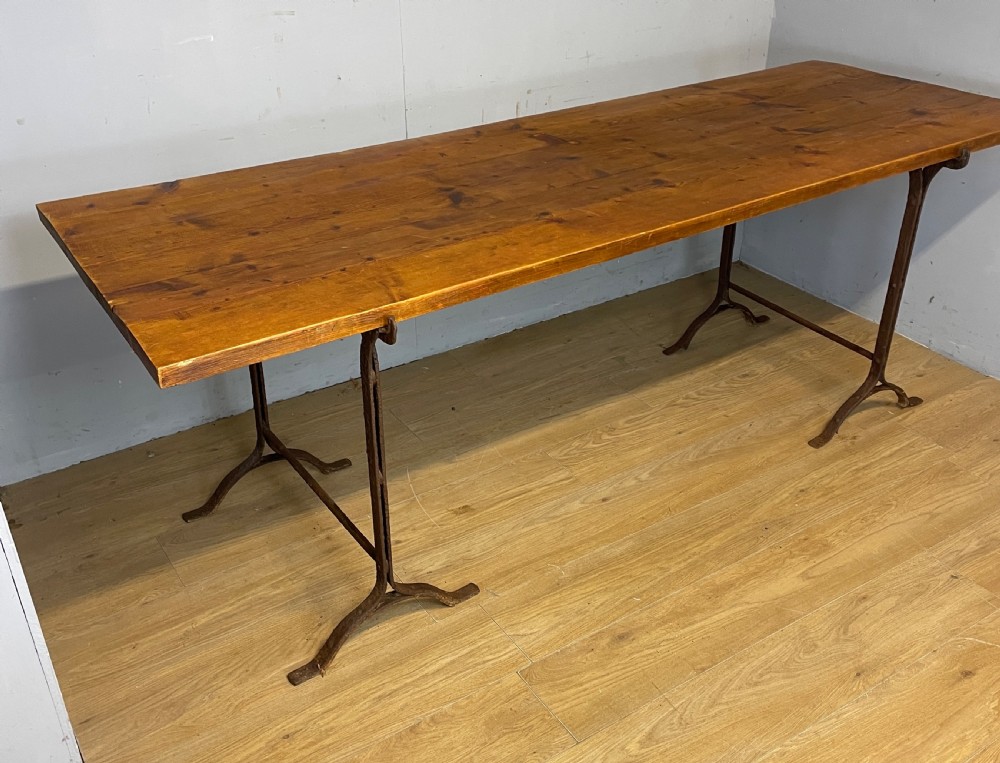 C19TH pine topped trestle table on wrought iron supports 