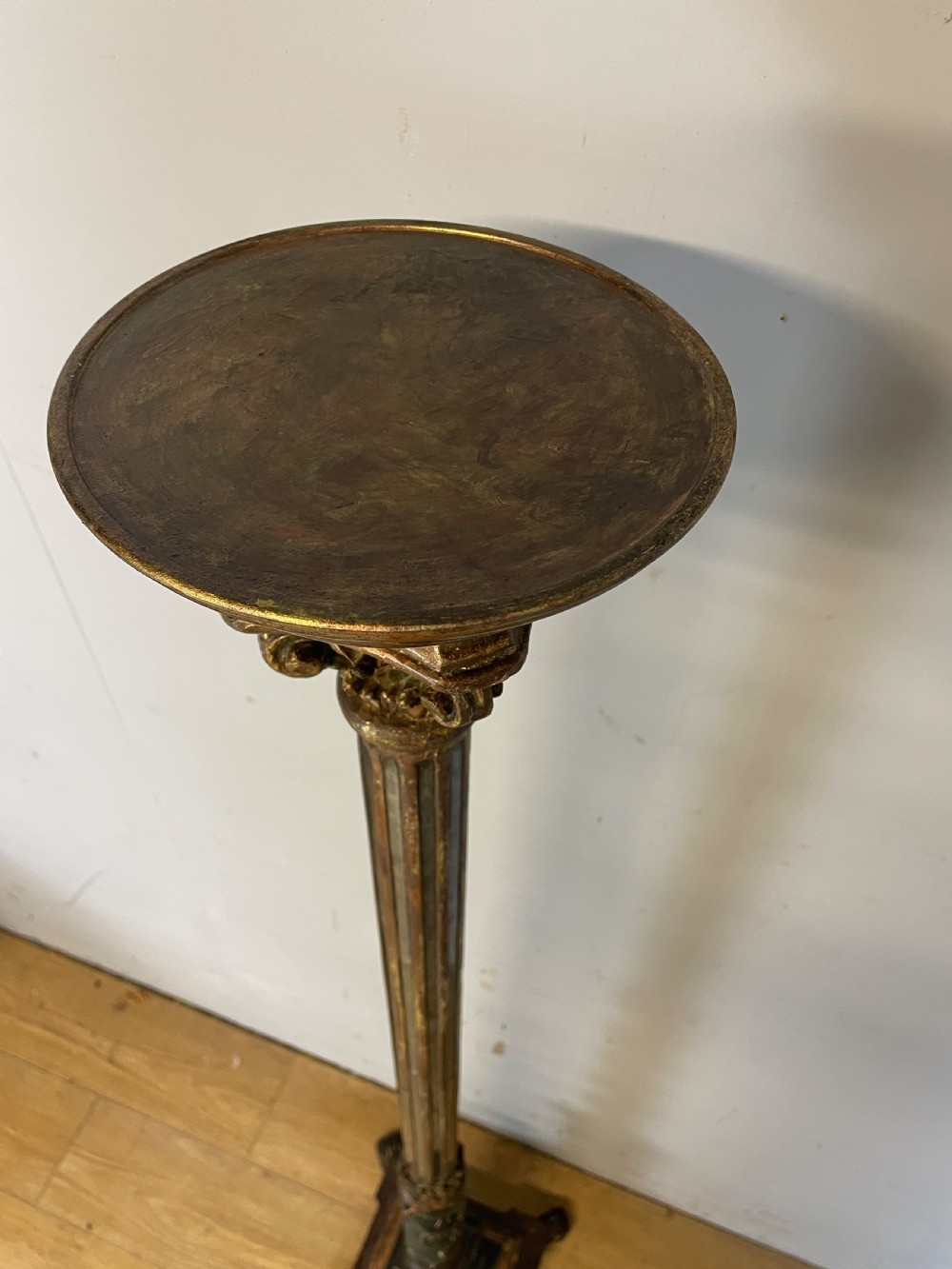 An 18th-century Italian carved wood torchere with a gilded Corinthian capital, fluted column, spiral twist shaft, and stepped base with scroll feet. View V