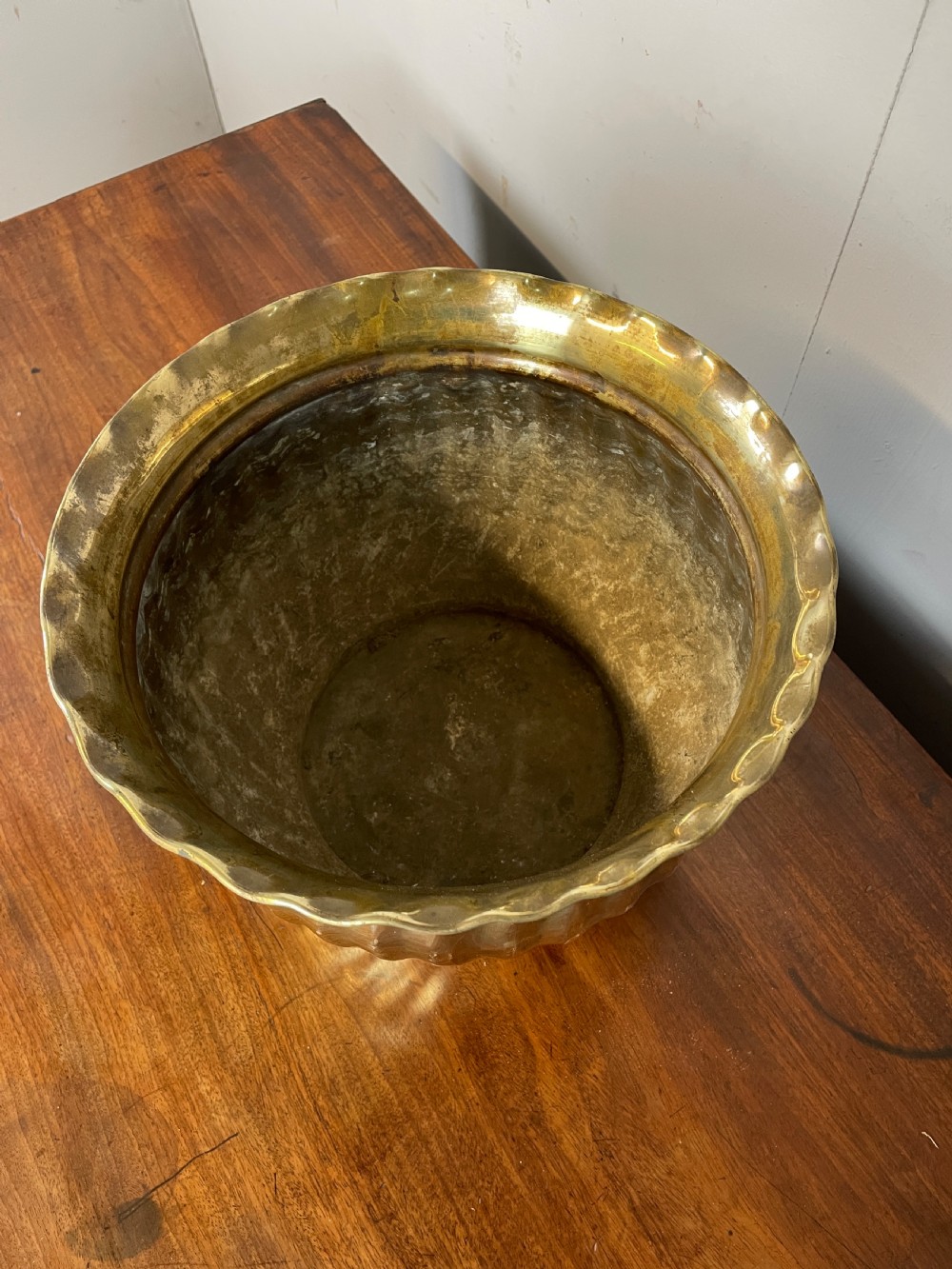 A round brass jardiniere with spiral fluted sides, a scalloped upper rim, and a flat circular base. View V