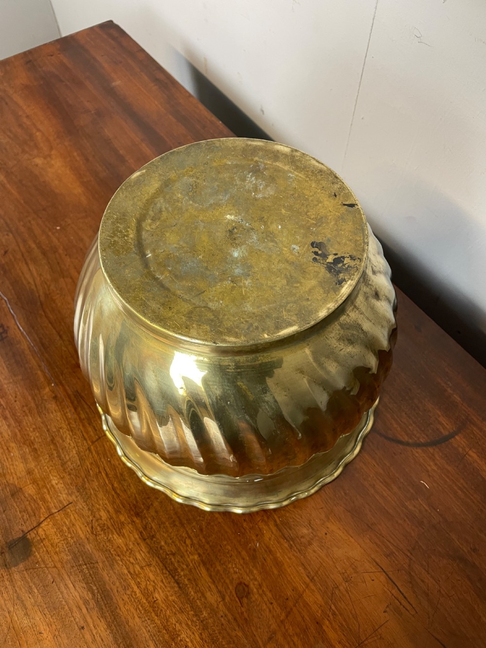A round brass jardiniere with spiral fluted sides, a scalloped upper rim, and a flat circular base. View VI