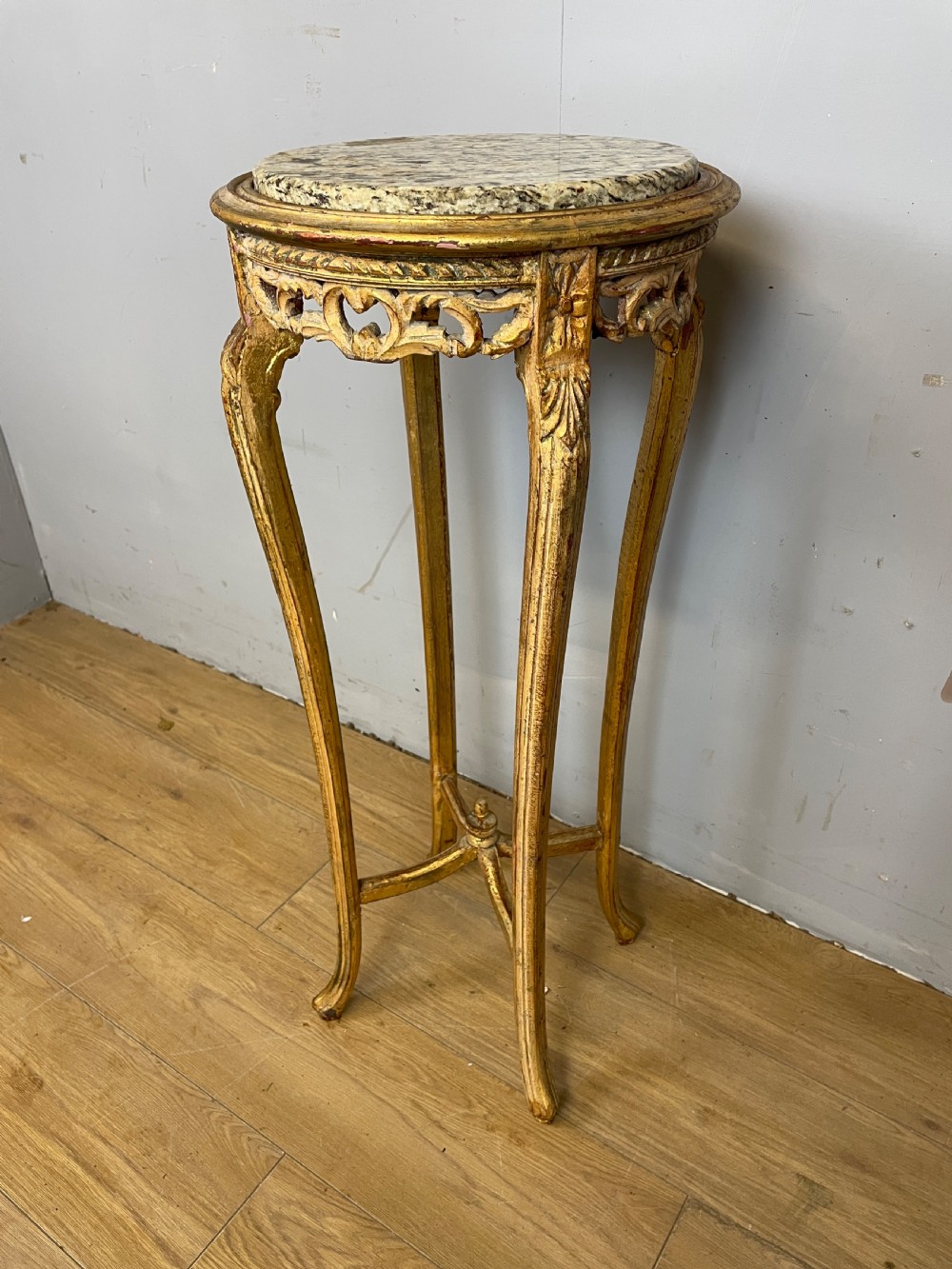 An Edwardian carved giltwood torchere featuring a circular grey marble top, slender cabriole legs, pierced aprons, and an X-frame stretcher. View IV