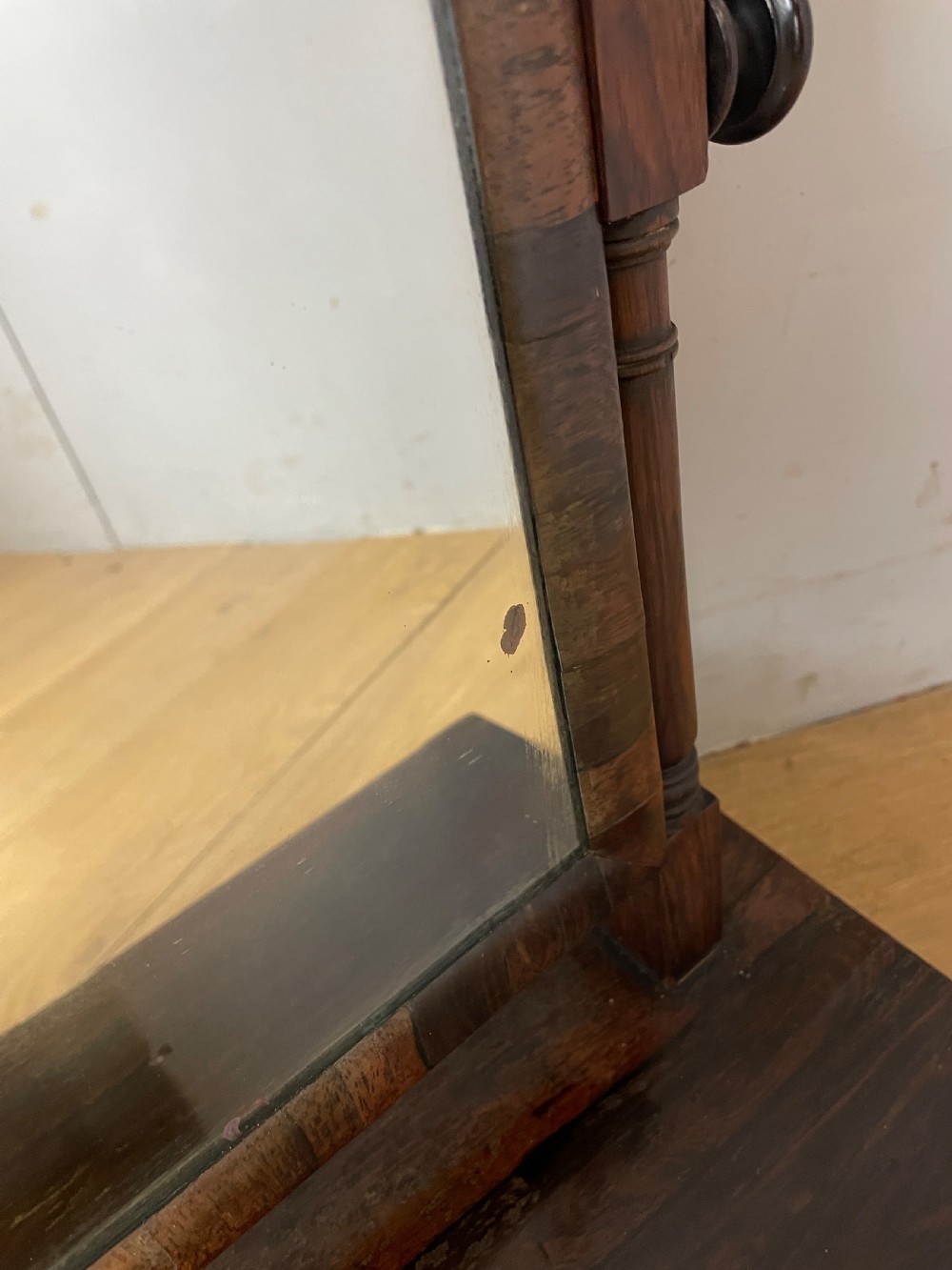 An early Victorian dark rosewood dressing table mirror featuring turned support columns, finials, and a rectangular swivelling frame resting on a plinth drawer base. View VIII