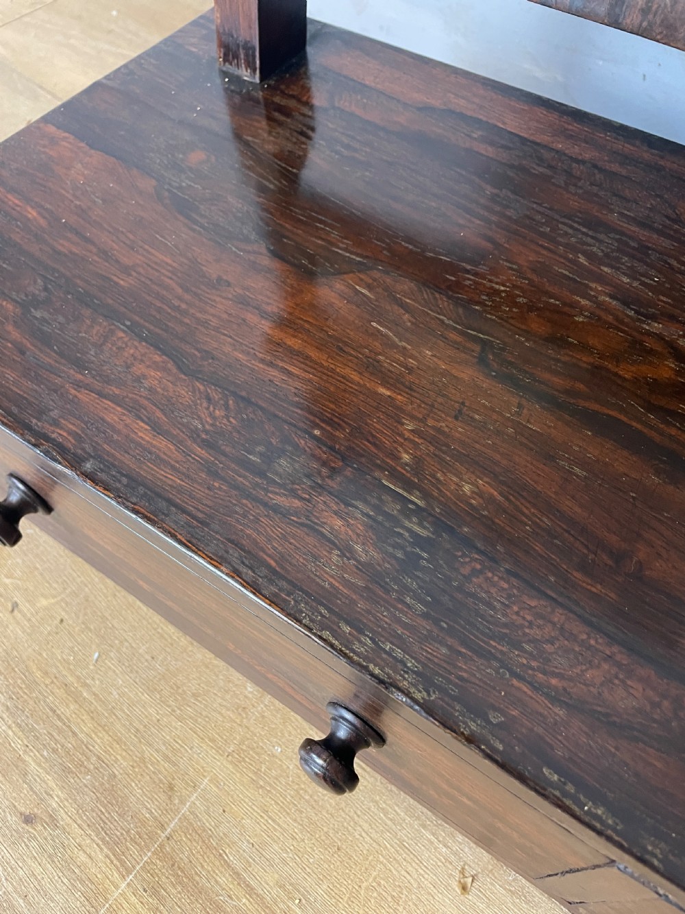 An early Victorian dark rosewood dressing table mirror featuring turned support columns, finials, and a rectangular swivelling frame resting on a plinth drawer base. View X