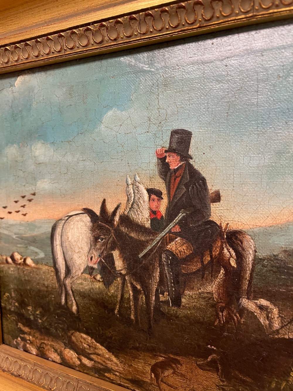A 19th-century oil painting on canvas depicting riders and dogs in a rural landscape set within a moulded gilt frame. View III