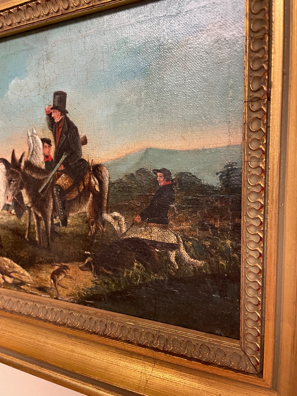 A 19th-century oil painting on canvas depicting riders and dogs in a rural landscape set within a moulded gilt frame. View IV