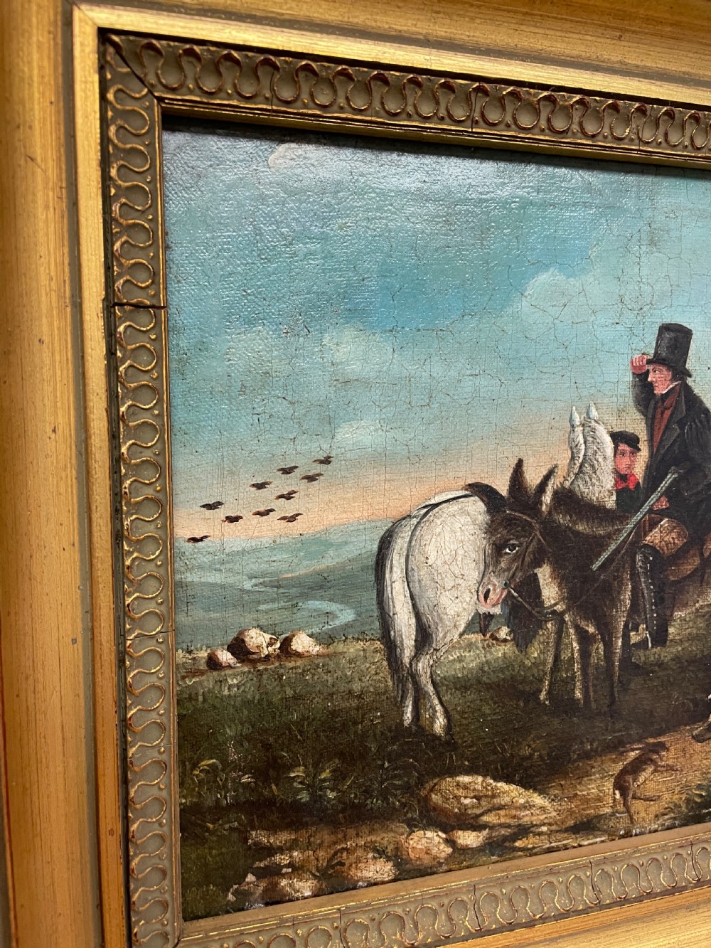 A 19th-century oil painting on canvas depicting riders and dogs in a rural landscape set within a moulded gilt frame. View VII