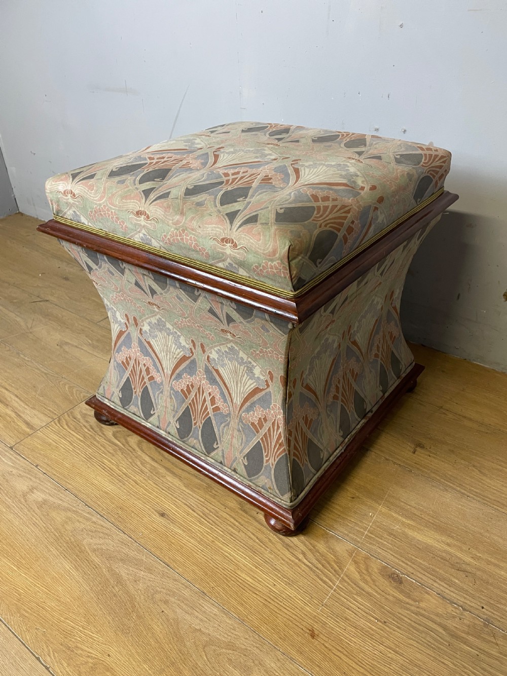 A nineteenth-century square waisted ottoman stool upholstered in a floral Liberty fabric with dark mahogany trim and bun feet. View III