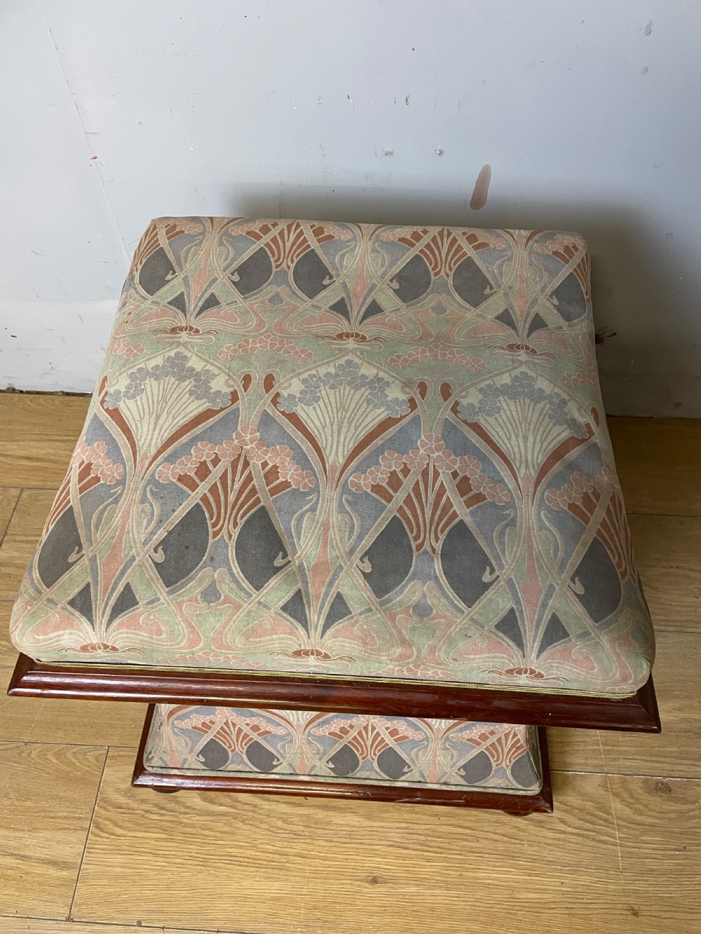 A nineteenth-century square waisted ottoman stool upholstered in a floral Liberty fabric with dark mahogany trim and bun feet. View IV