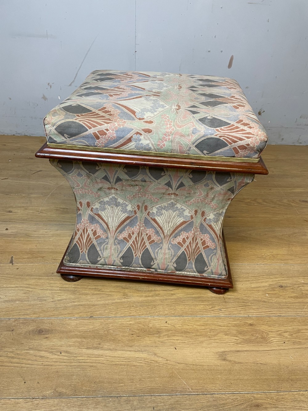 A nineteenth-century square waisted ottoman stool upholstered in a floral Liberty fabric with dark mahogany trim and bun feet. View VIII