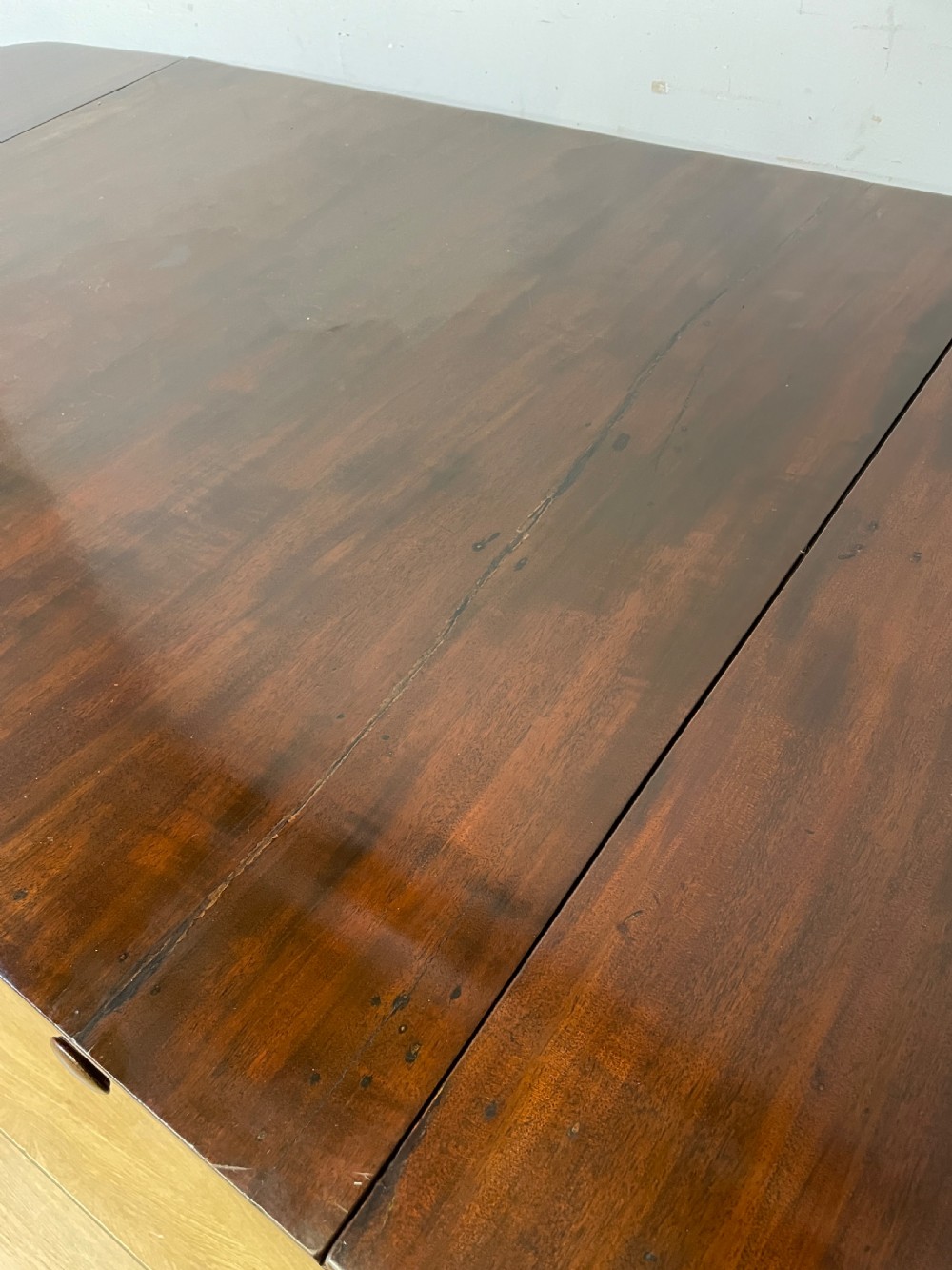 A dark mahogany Regency writing table featuring two drawers with wooden knobs, drop-leaf sides, and spiral-twisted legs on brass castors. View VIII