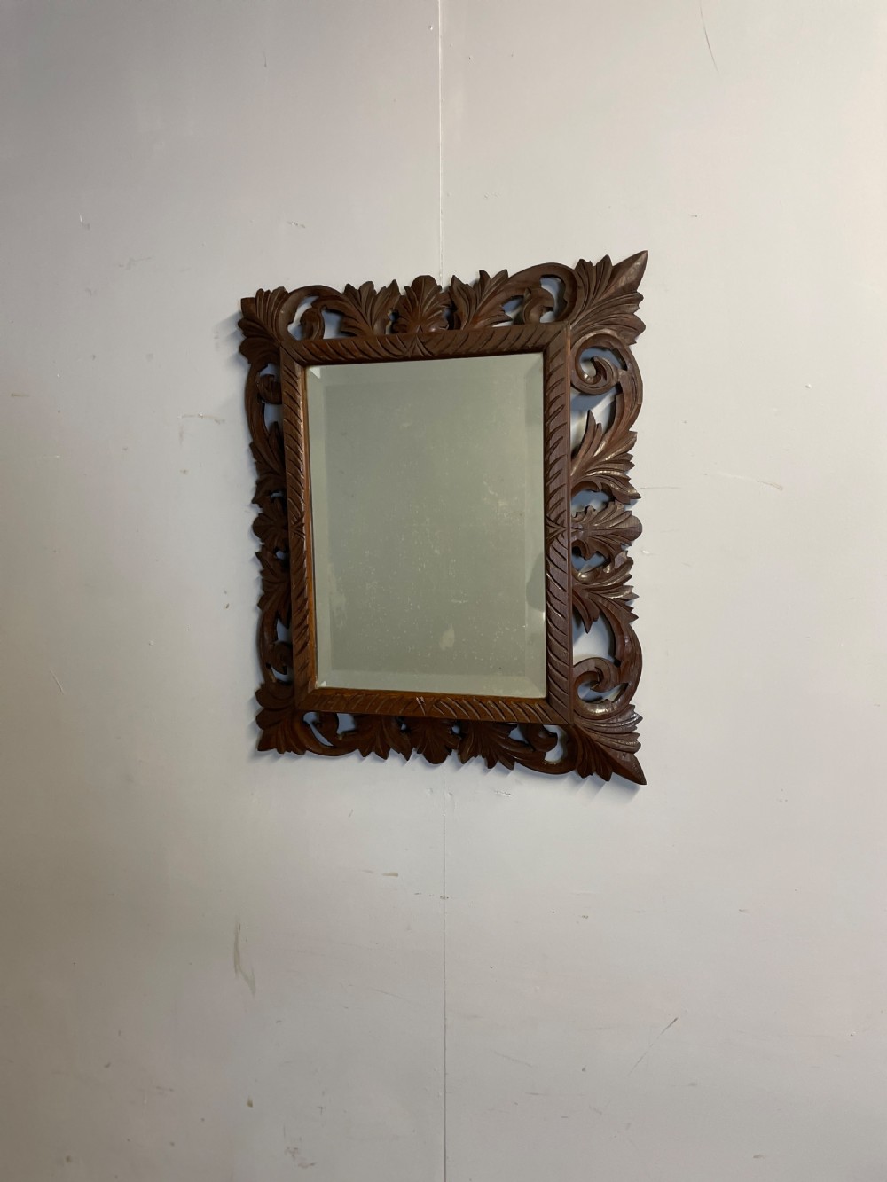 A rectangular 19th-century wall mirror with a bevelled glass plate set inside a deeply carved oak frame featuring acanthus leaves. View II
