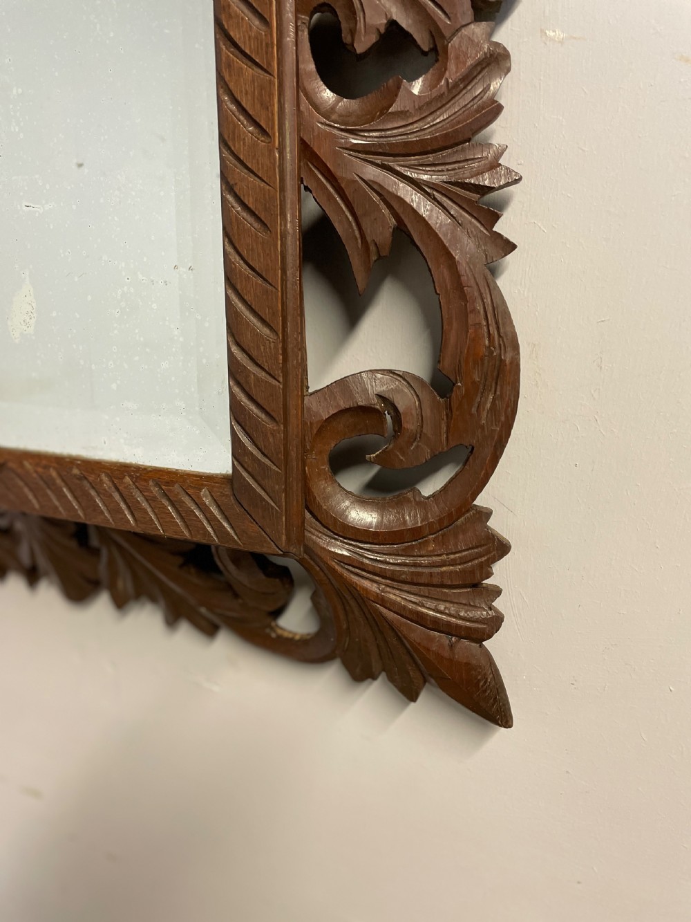 A rectangular 19th-century wall mirror with a bevelled glass plate set inside a deeply carved oak frame featuring acanthus leaves. View III