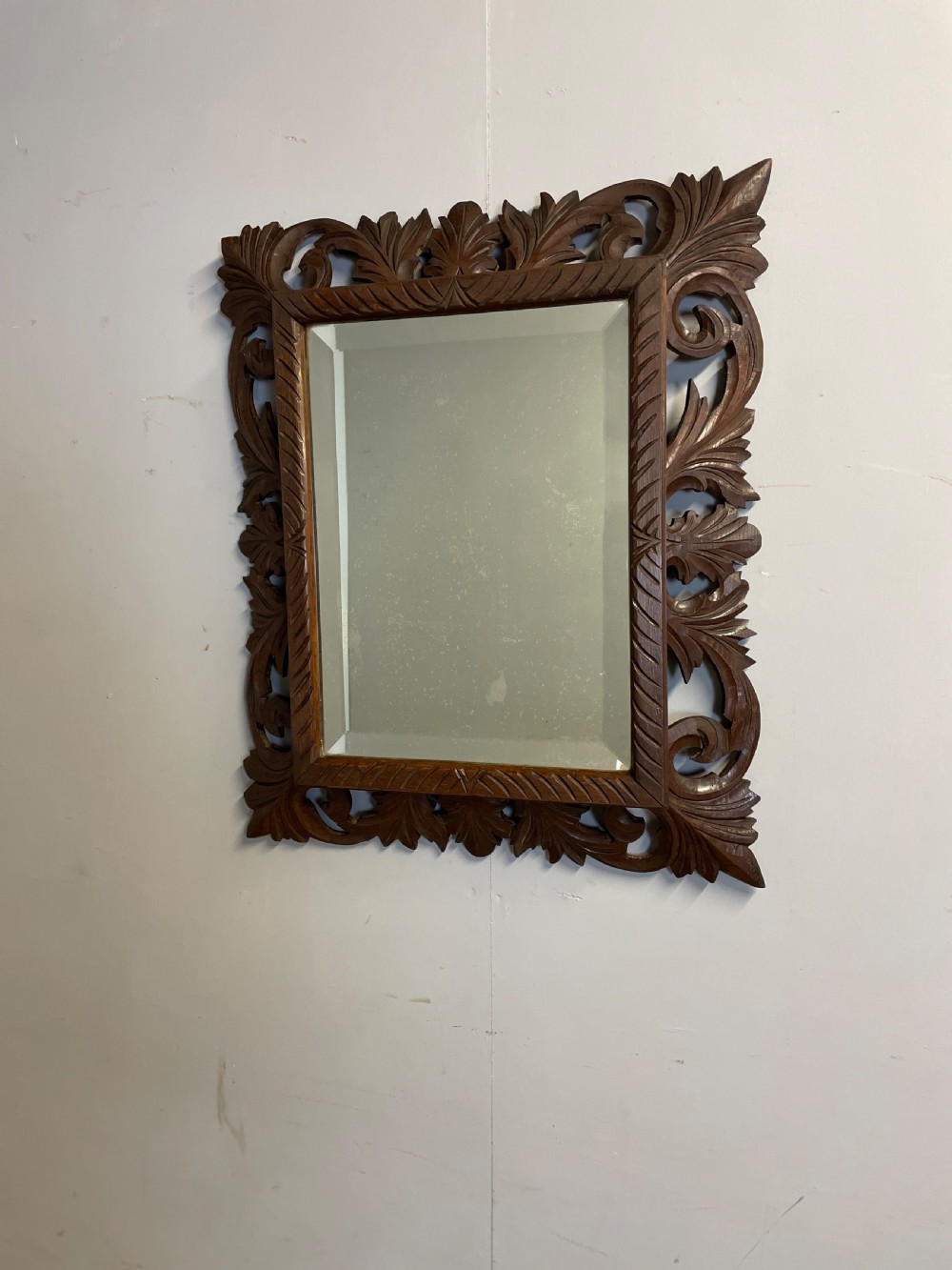 A rectangular 19th-century wall mirror with a bevelled glass plate set inside a deeply carved oak frame featuring acanthus leaves. View VI