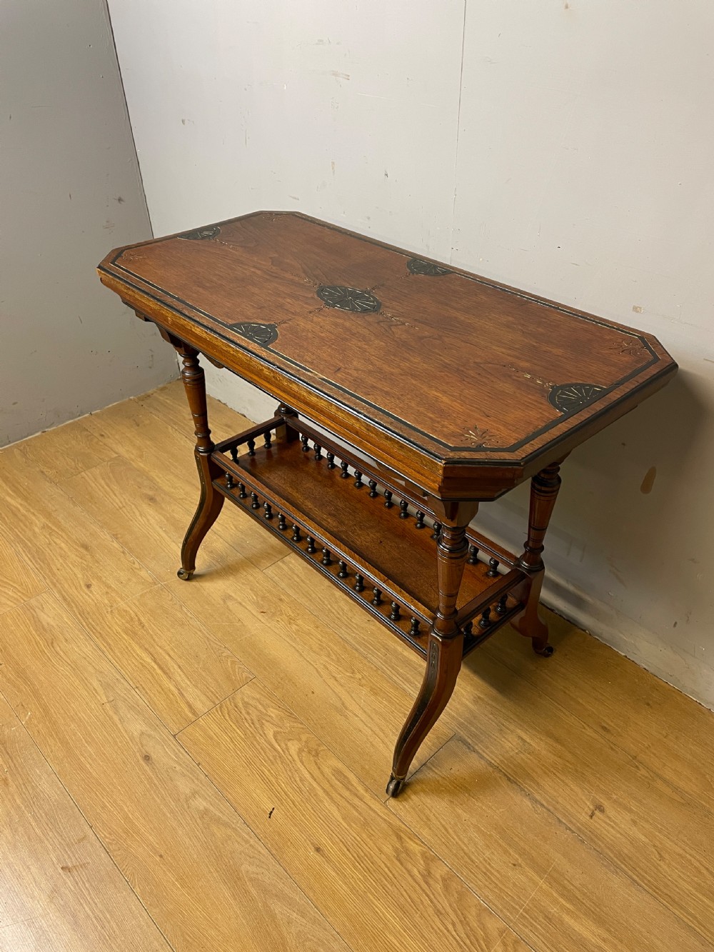 A late 19th-century Aesthetic Movement oak card table with incised top decorations, turned legs, and a lower spindle gallery shelf. View II