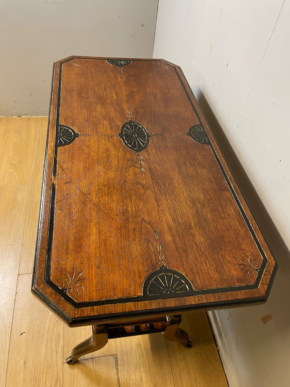 A late 19th-century Aesthetic Movement oak card table with incised top decorations, turned legs, and a lower spindle gallery shelf. View III