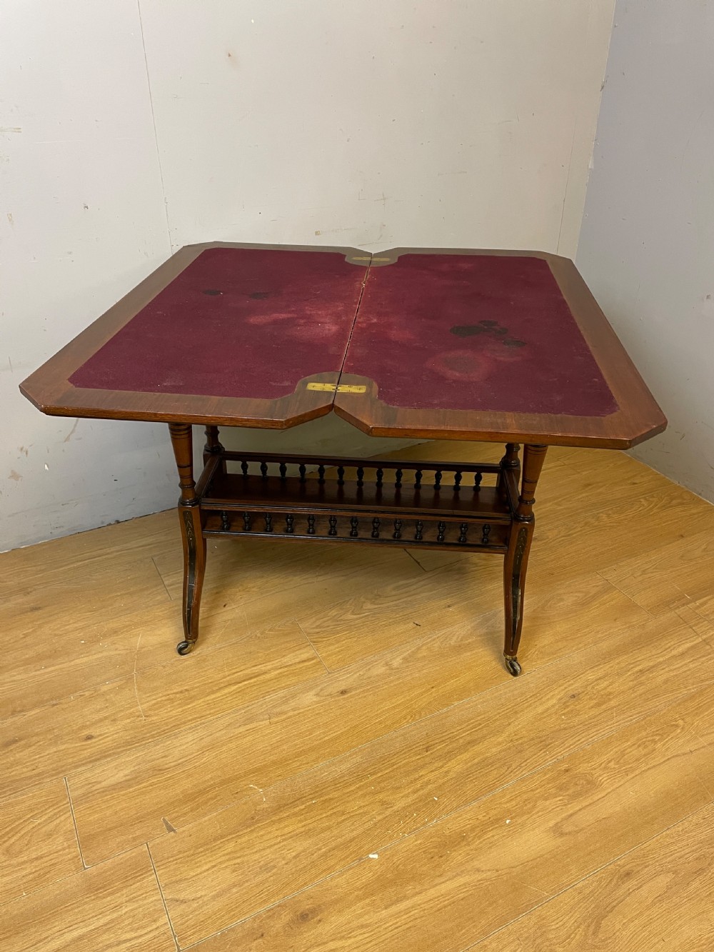 A late 19th-century Aesthetic Movement oak card table with incised top decorations, turned legs, and a lower spindle gallery shelf. View VII