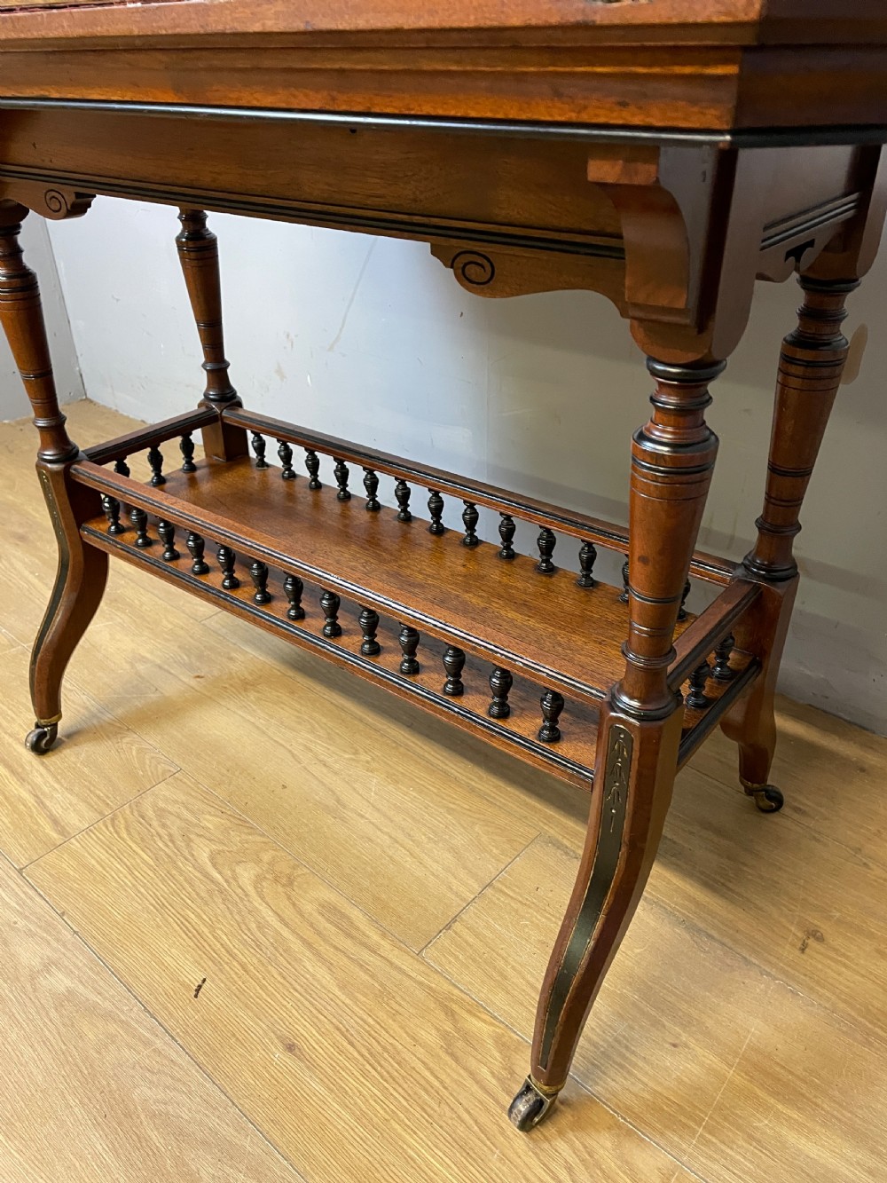 A late 19th-century Aesthetic Movement oak card table with incised top decorations, turned legs, and a lower spindle gallery shelf. View XII