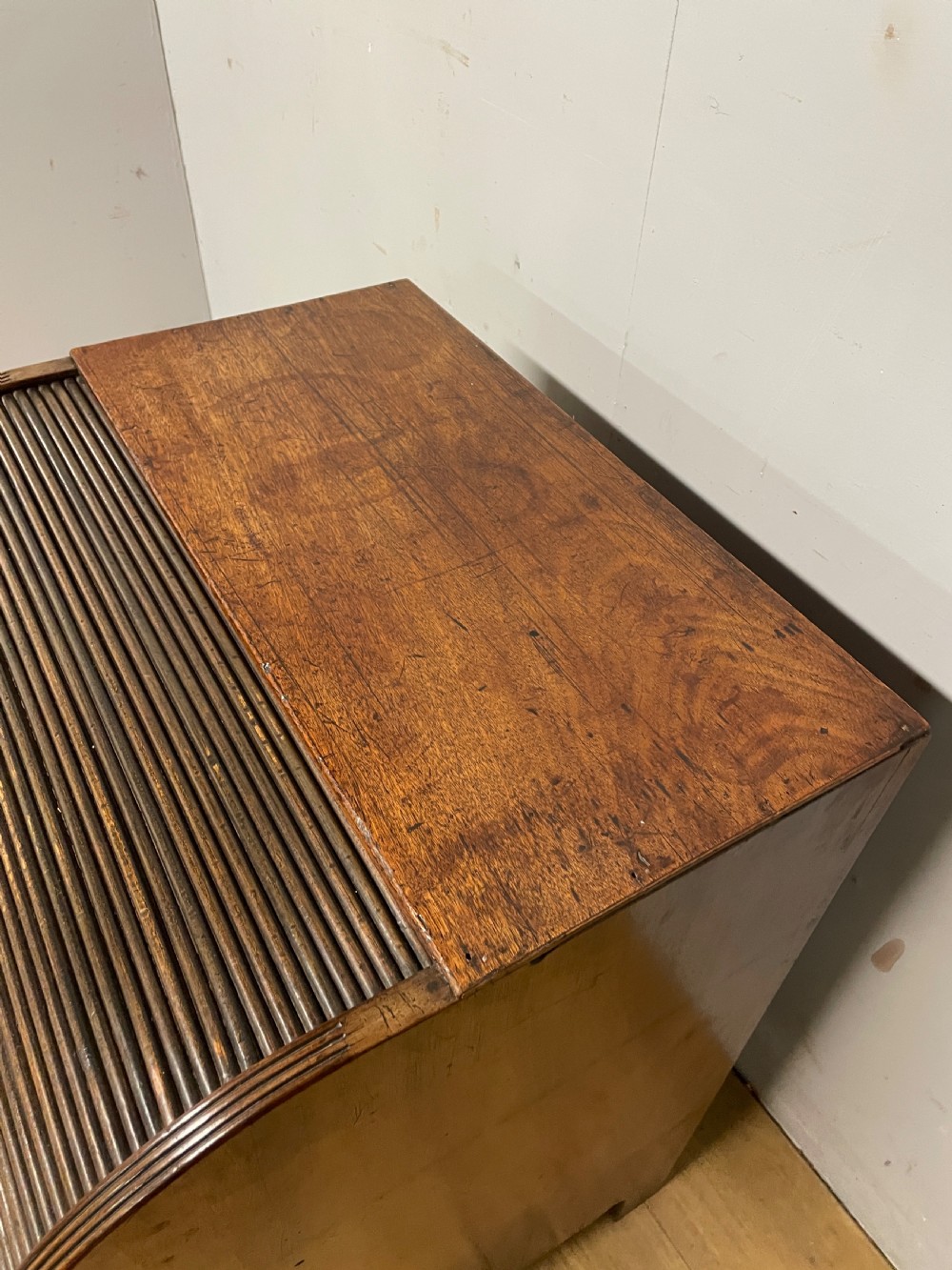 A Georgian mahogany bureau cabinet featuring a curved slatted tambour shutter above four small drawers and two wide drawers with brass handles. View V