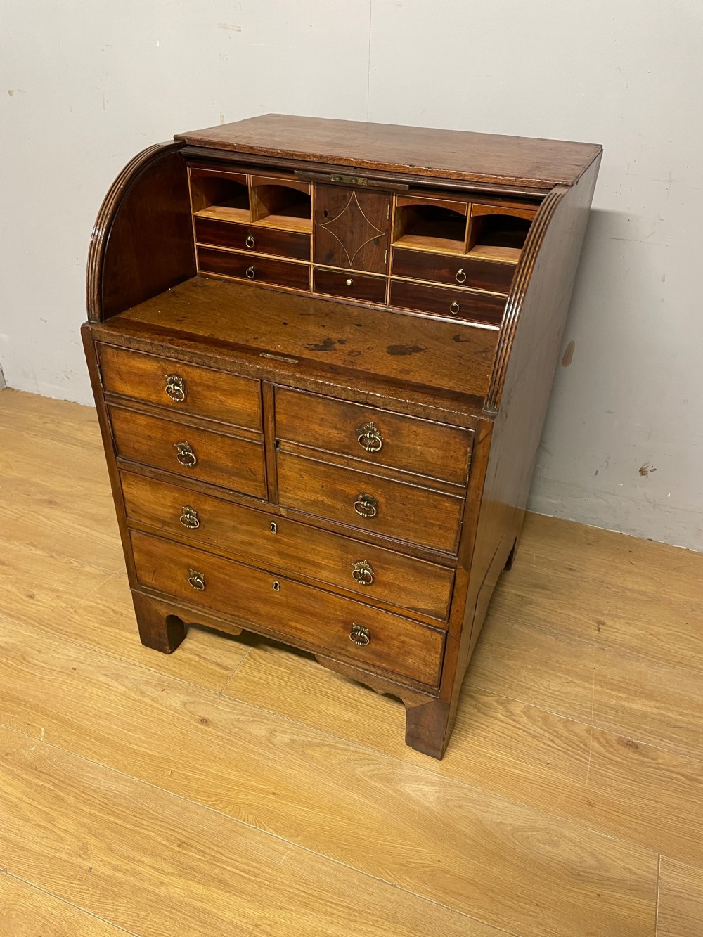 A Georgian mahogany bureau cabinet featuring a curved slatted tambour shutter above four small drawers and two wide drawers with brass handles. View VII