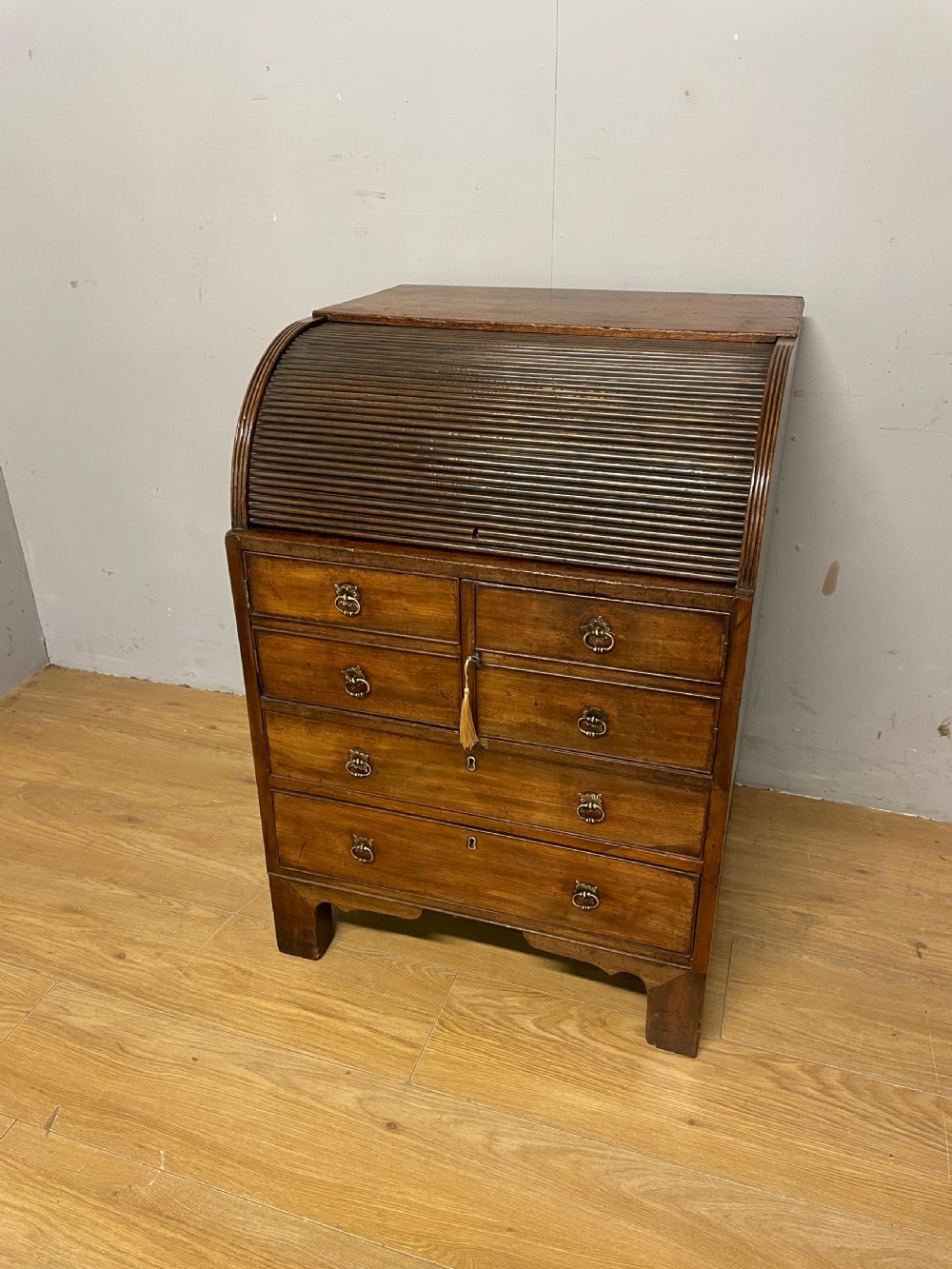 A Georgian mahogany bureau cabinet featuring a curved slatted tambour shutter above four small drawers and two wide drawers with brass handles. View VIII