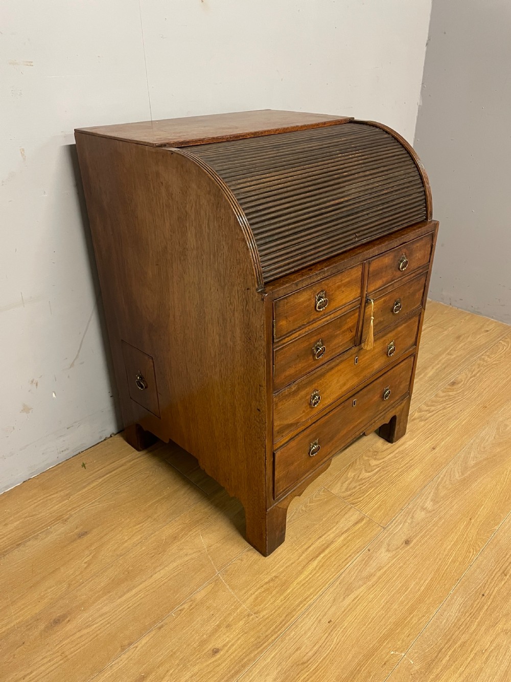 A Georgian mahogany bureau cabinet featuring a curved slatted tambour shutter above four small drawers and two wide drawers with brass handles. View IX