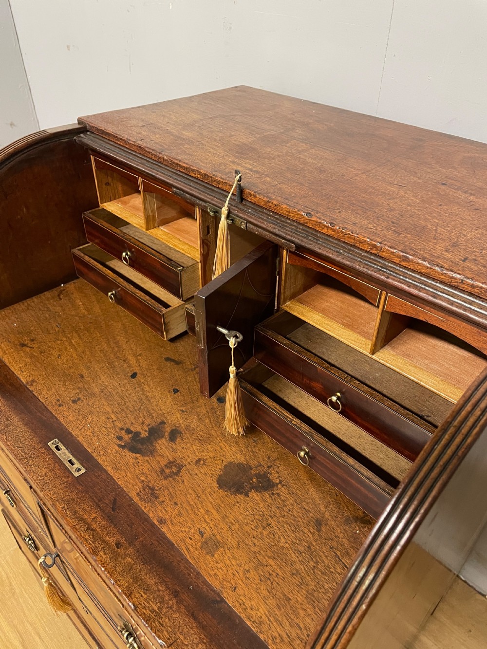A Georgian mahogany bureau cabinet featuring a curved slatted tambour shutter above four small drawers and two wide drawers with brass handles. View XI