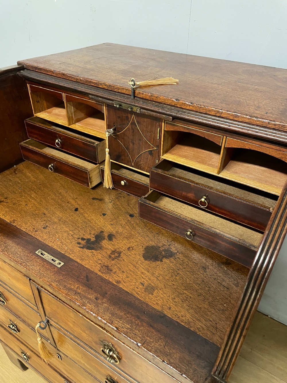 A Georgian mahogany bureau cabinet featuring a curved slatted tambour shutter above four small drawers and two wide drawers with brass handles. View XII