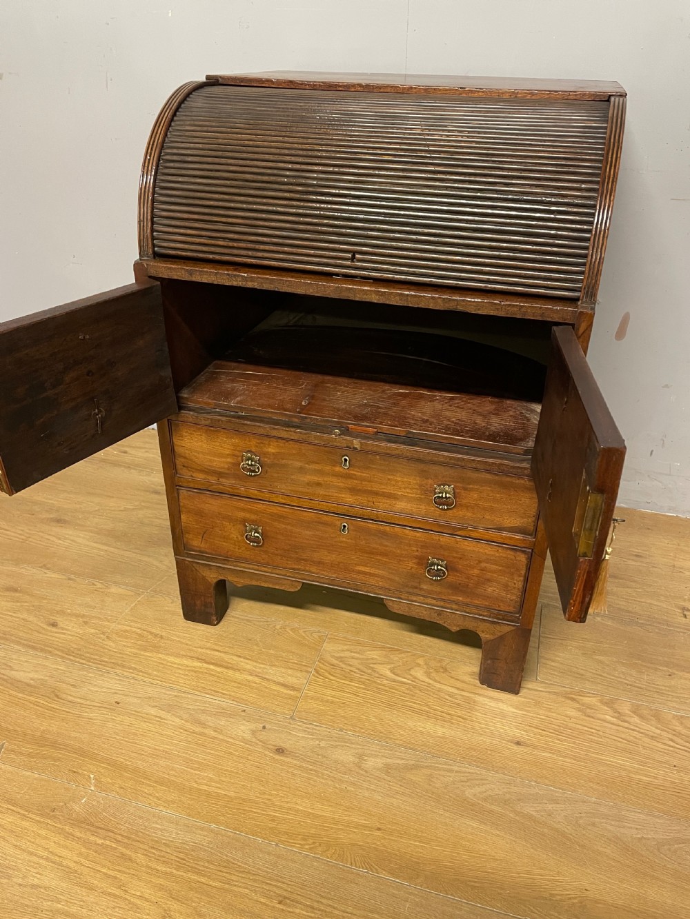 A Georgian mahogany bureau cabinet featuring a curved slatted tambour shutter above four small drawers and two wide drawers with brass handles. View XIV