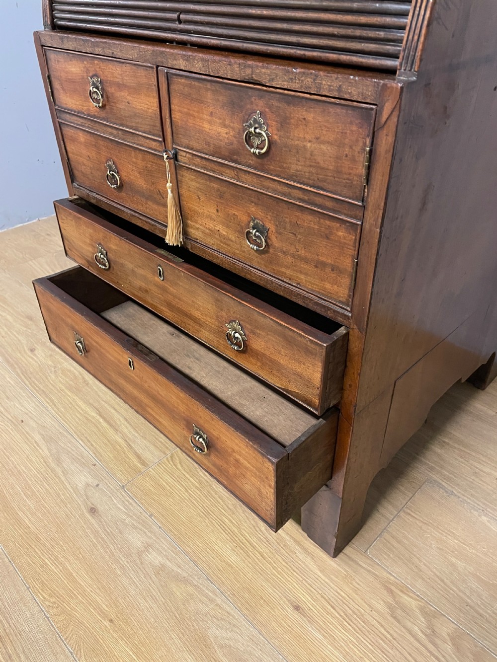 A Georgian mahogany bureau cabinet featuring a curved slatted tambour shutter above four small drawers and two wide drawers with brass handles. View XV