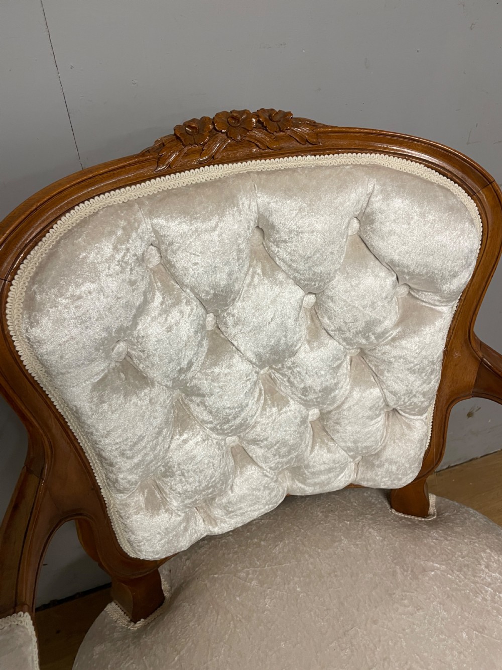 A Louis XV style solid walnut armchair featuring button-tufted cream velvet upholstery, carved cresting, and cabriole legs. View IV
