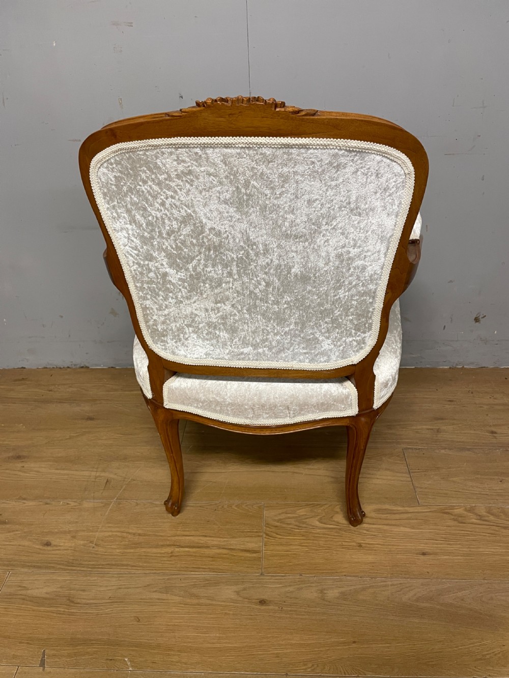A Louis XV style solid walnut armchair featuring button-tufted cream velvet upholstery, carved cresting, and cabriole legs. View VI