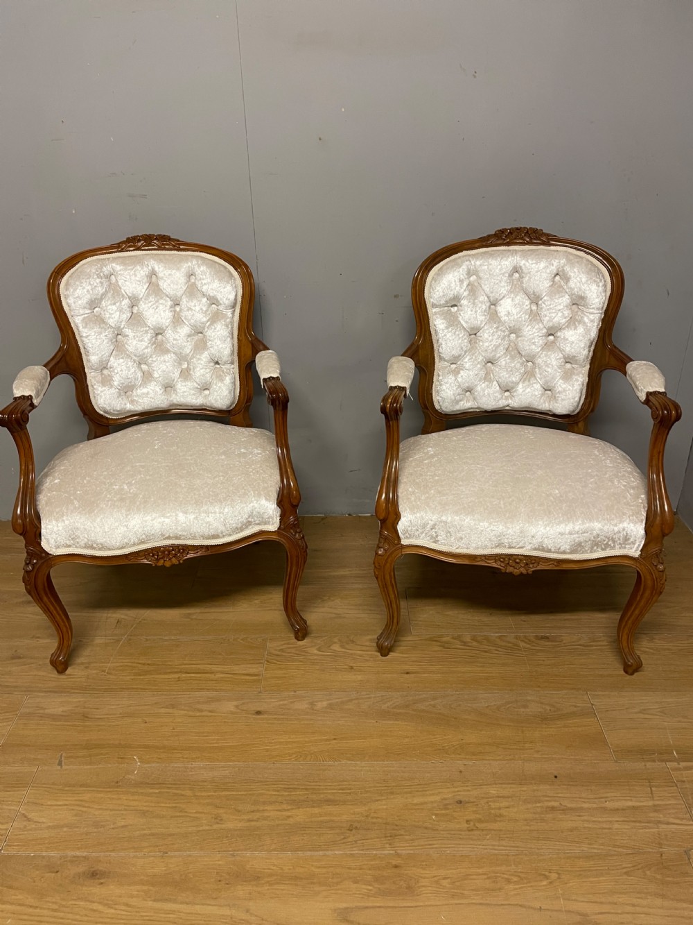 A Louis XV style solid walnut armchair featuring button-tufted cream velvet upholstery, carved cresting, and cabriole legs. View VII