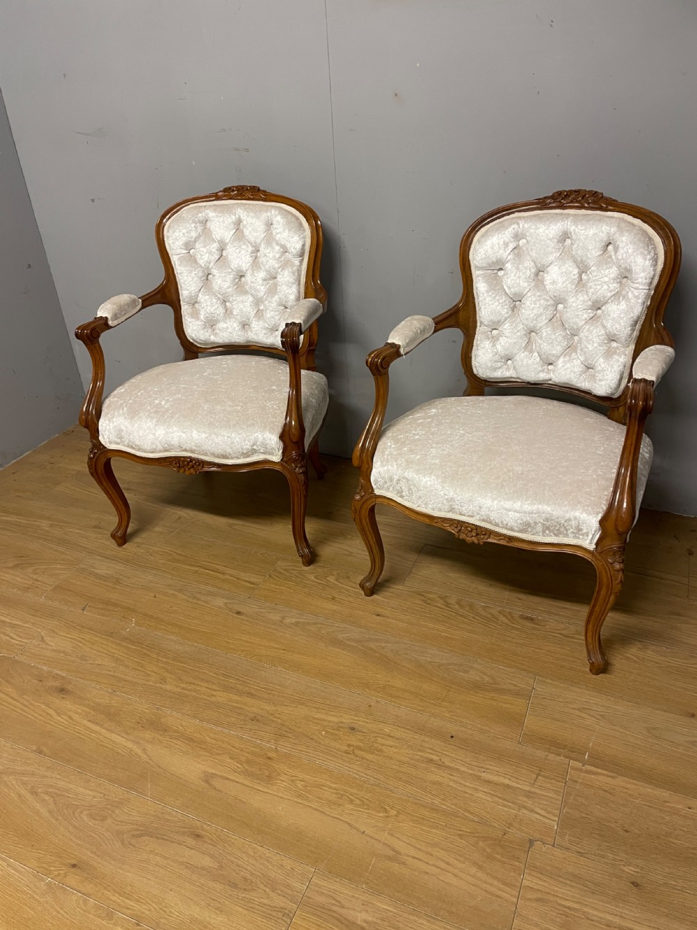 A Louis XV style solid walnut armchair featuring button-tufted cream velvet upholstery, carved cresting, and cabriole legs. View VIII