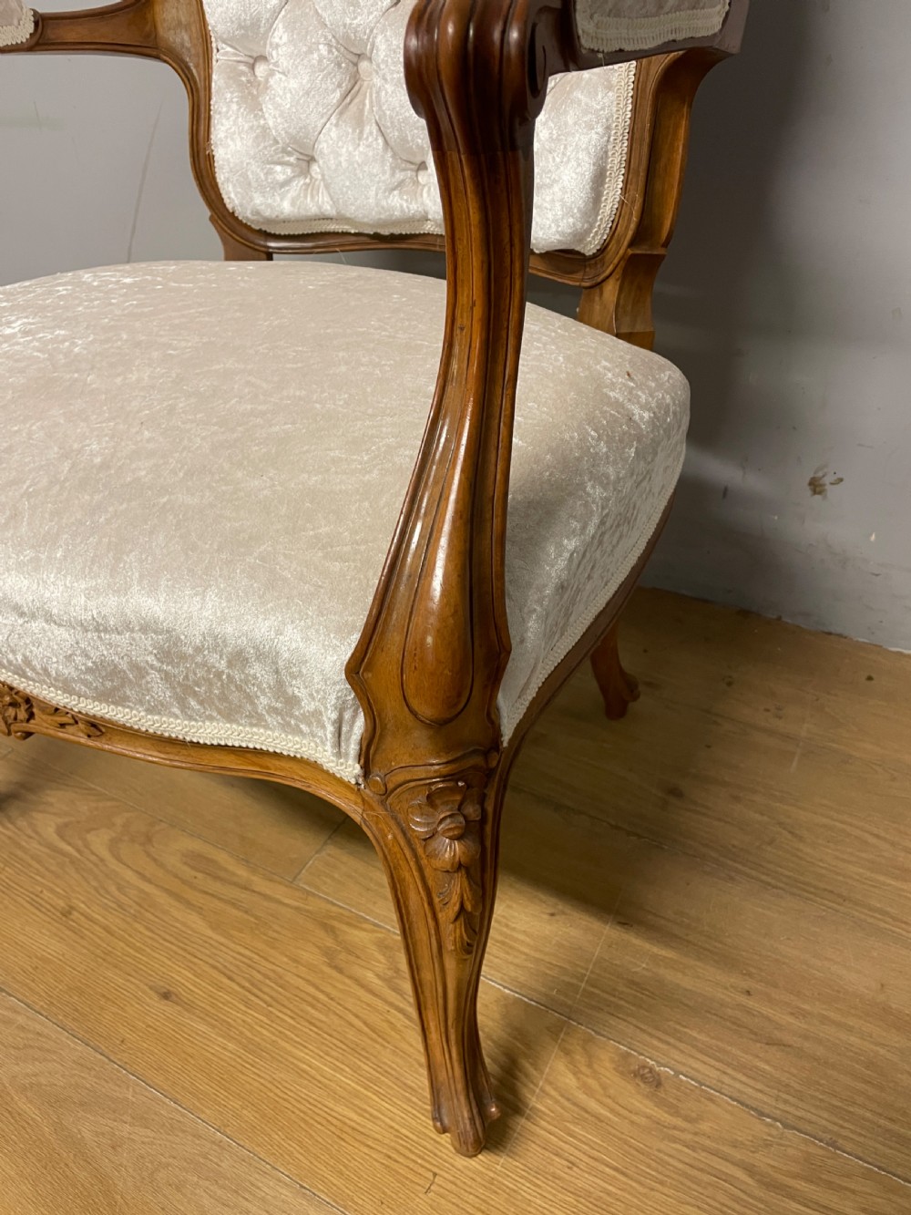 A carved walnut armchair featuring a deep button-tufted cream velvet backrest, padded armrests, and curved cabriole legs. View III