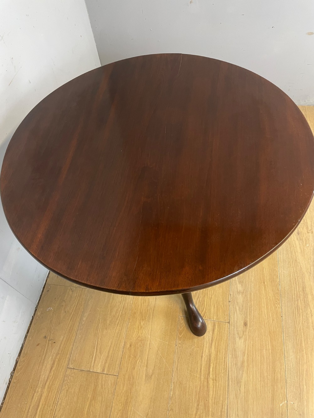 A late eighteenth-century Georgian mahogany tripod table featuring a circular top, a turned gun barrel stem, and three splayed legs. View IV