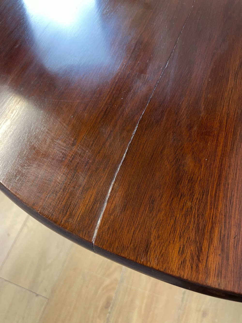A late eighteenth-century Georgian mahogany tripod table featuring a circular top, a turned gun barrel stem, and three splayed legs. View V