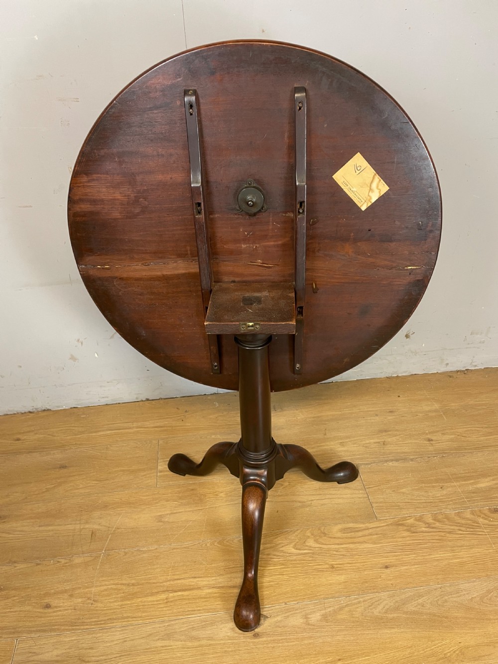 A late eighteenth-century Georgian mahogany tripod table featuring a circular top, a turned gun barrel stem, and three splayed legs. View VII