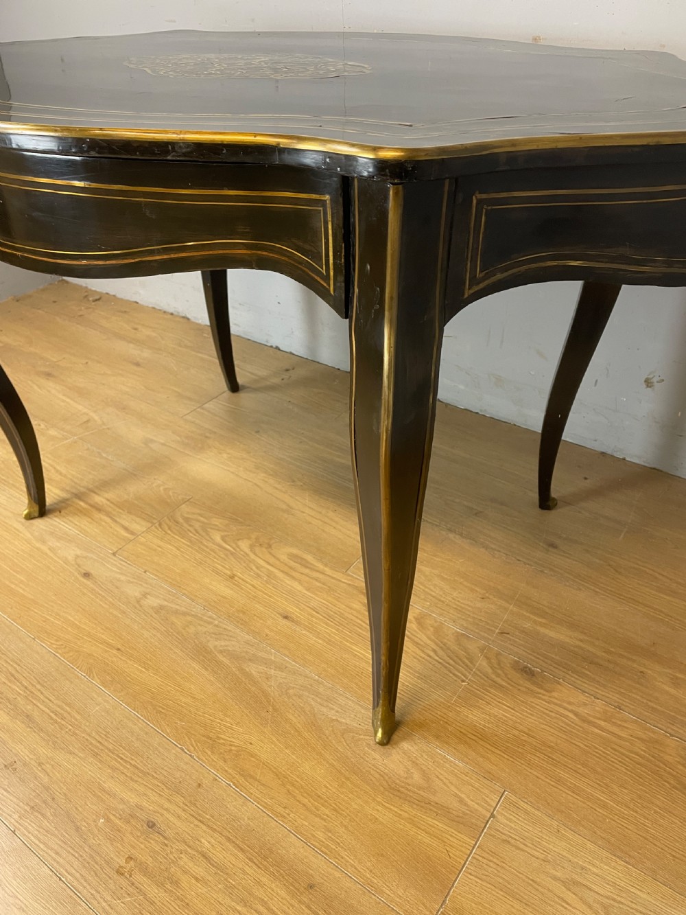 A 19th-century French ebonised writing table featuring brass inlay, a serpentine shaped top, and cabriole legs. View III