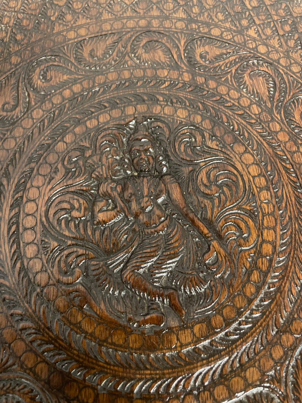 A circular 19th-century Anglo-Indian dark wood side table with intricate hand-carved floral patterns on the tabletop and cabriole legs. View VII