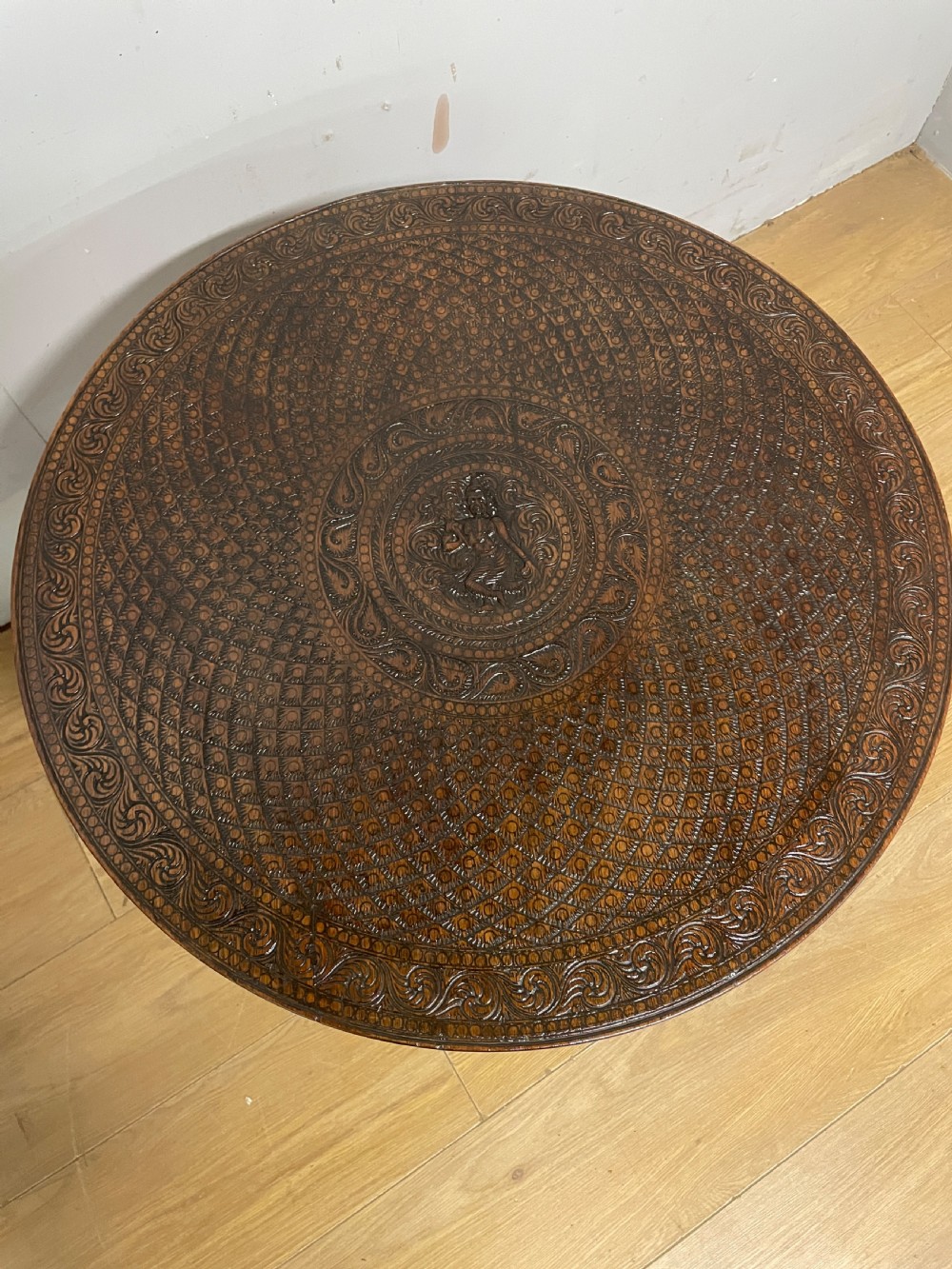 A circular 19th-century Anglo-Indian dark wood side table with intricate hand-carved floral patterns on the tabletop and cabriole legs. View VIII