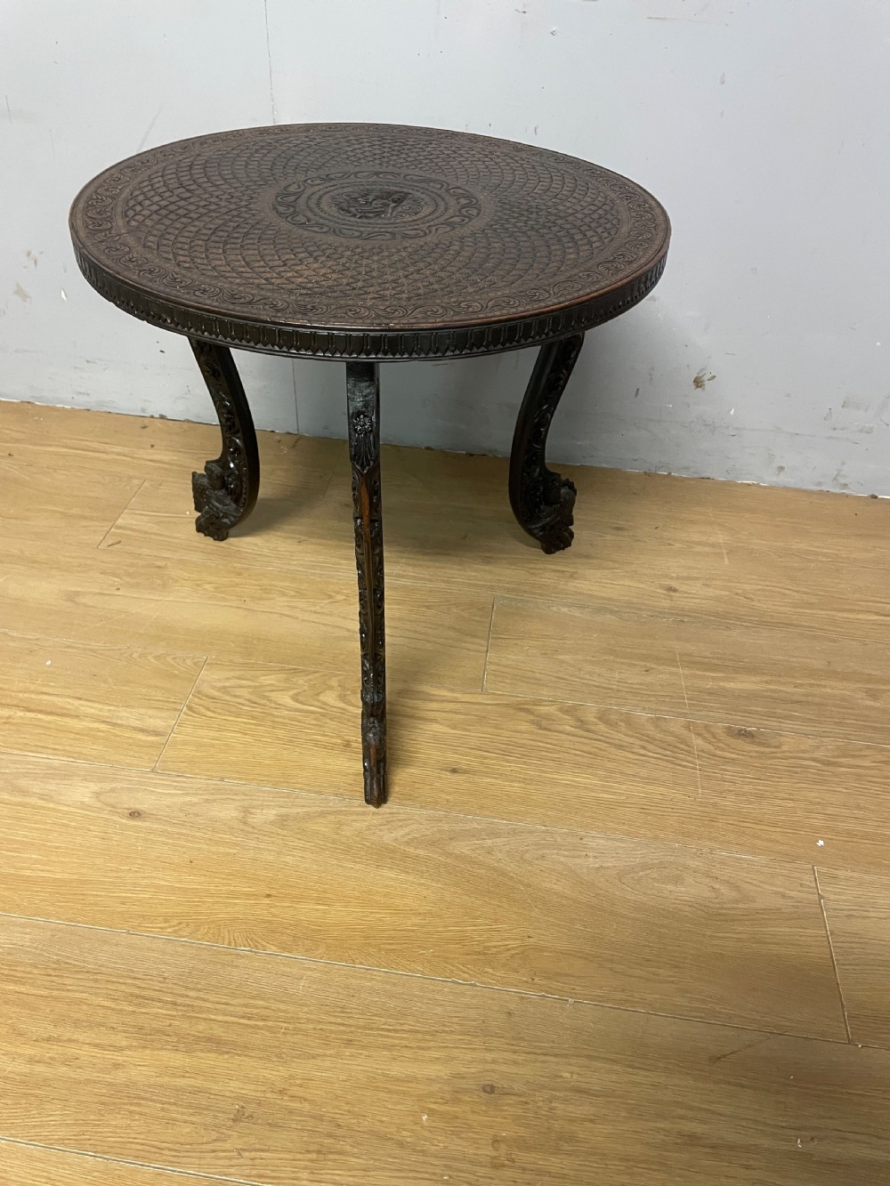 A circular 19th-century Anglo-Indian dark wood side table with intricate hand-carved floral patterns on the tabletop and cabriole legs. View IX