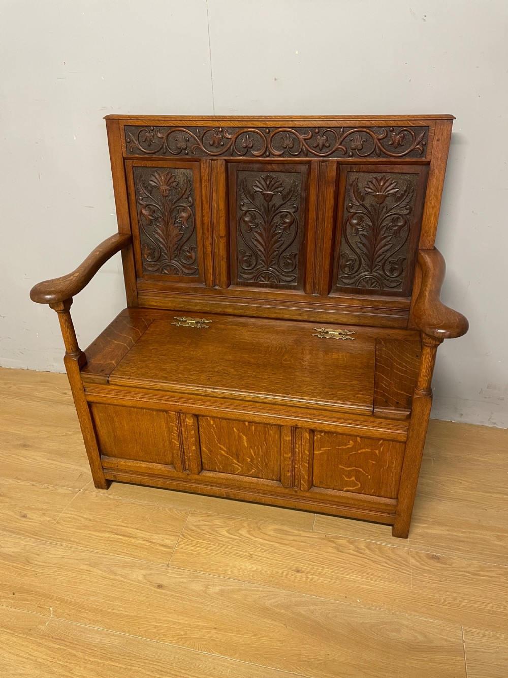 Late C19th golden oak Arts and Crafts carved box settle