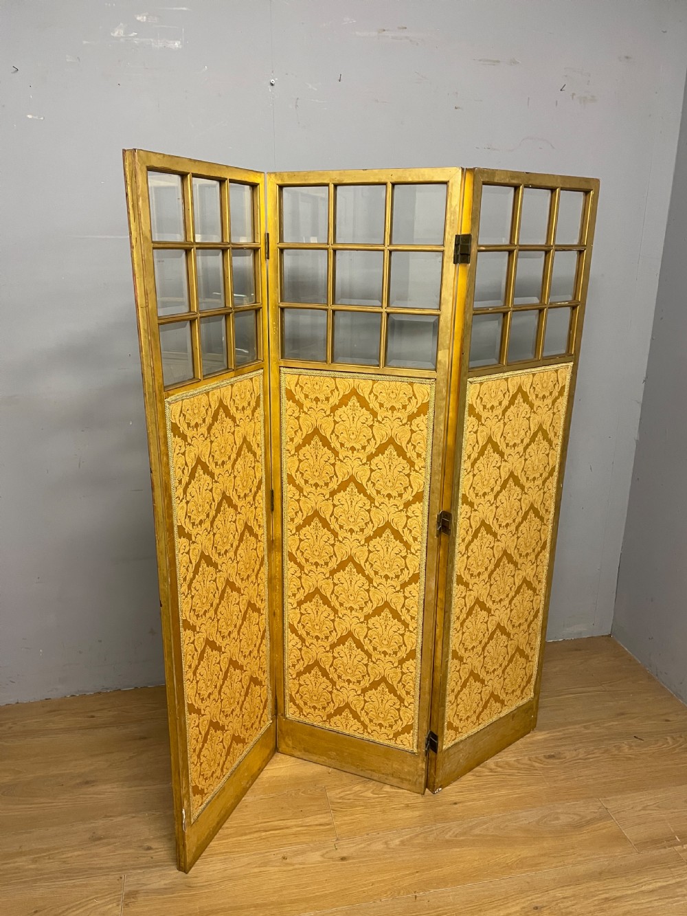 A nineteenth-century three-panel giltwood folding screen featuring glazed upper window panes and golden damask upholstered lower sections. View IX