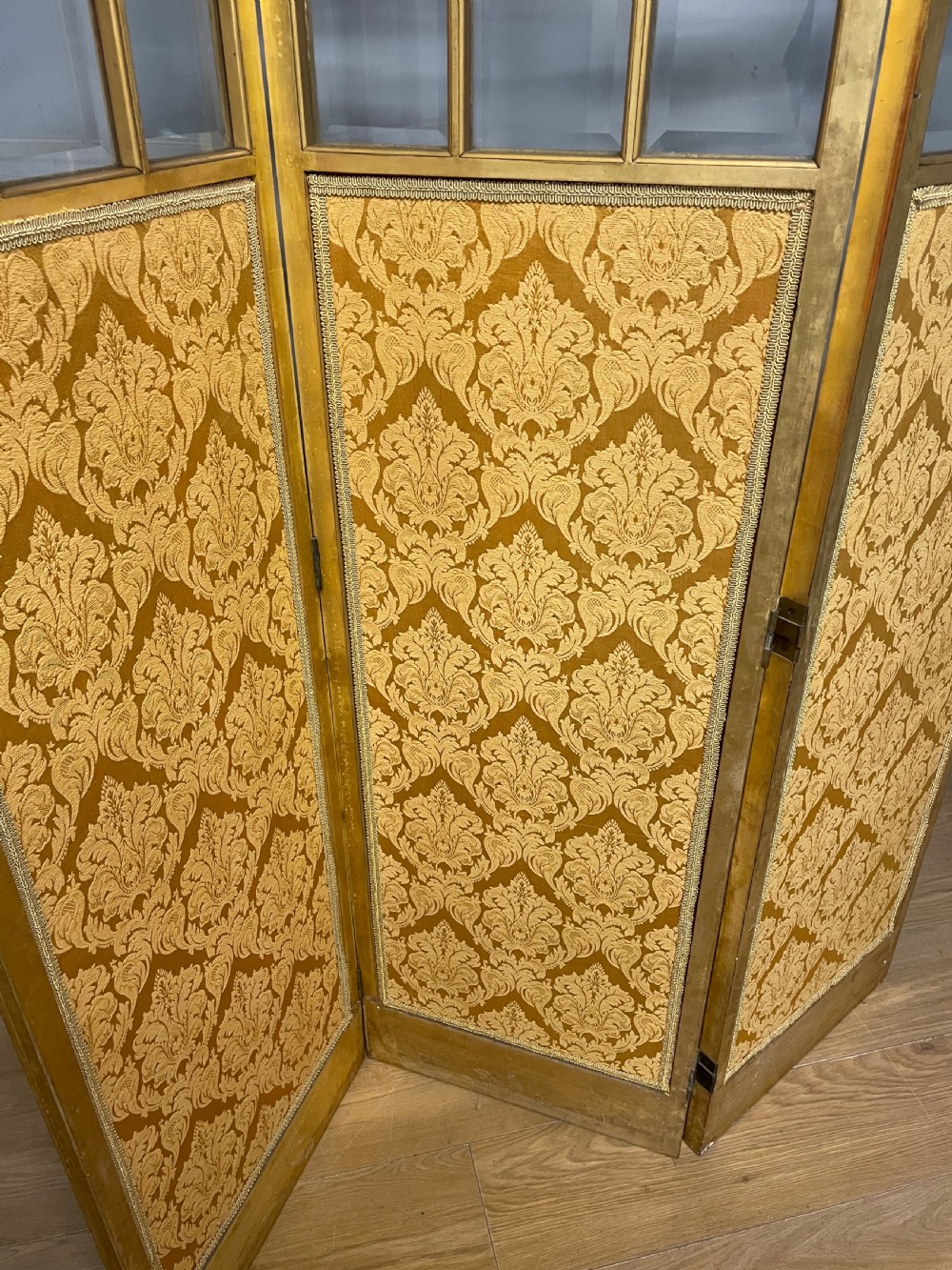 A nineteenth-century three-panel giltwood folding screen featuring glazed upper window panes and golden damask upholstered lower sections. View X
